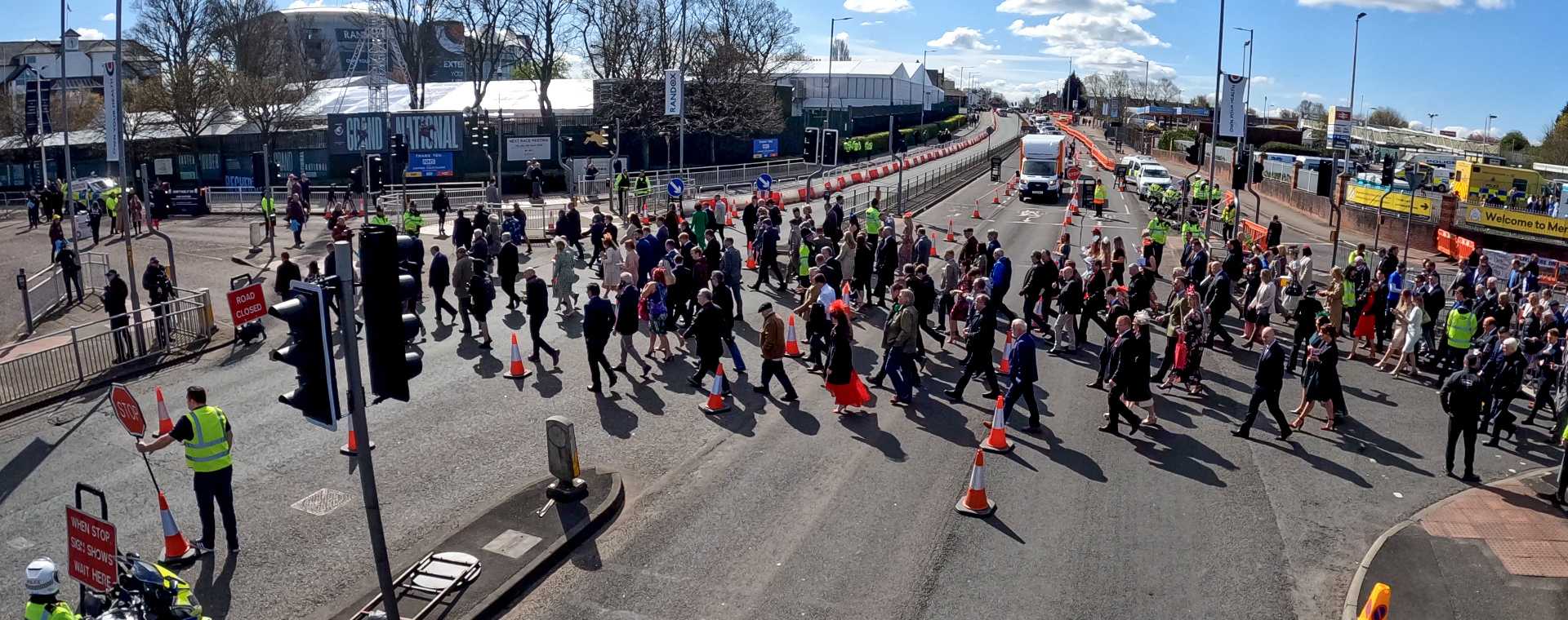 An aerial view of a crowd of people crossing a street.