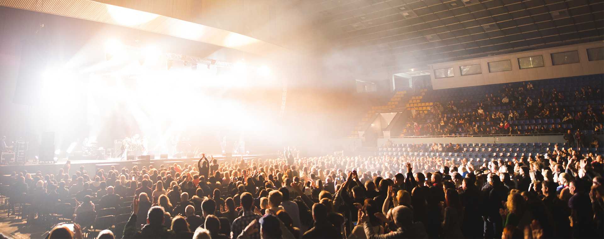 An audience watching a live performance in a stadium