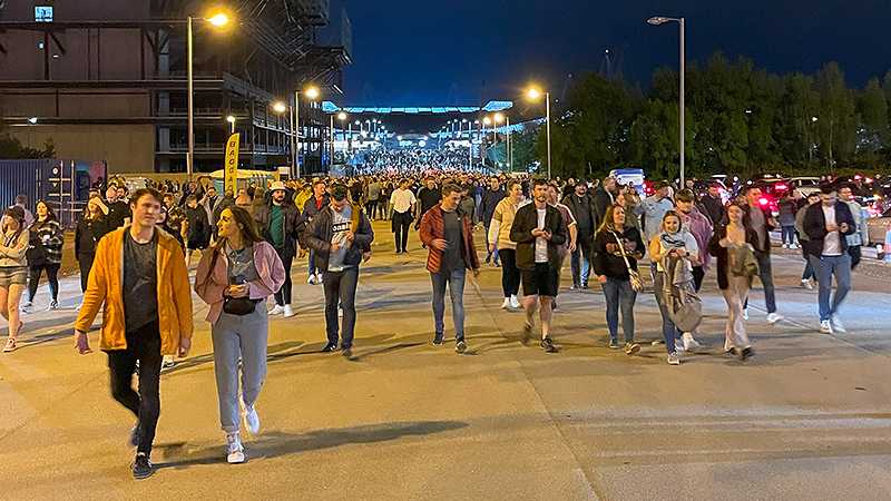A crowd of people walking down a street at night